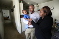 Andre Wiley holds his 7-month-old son, Amir, with his wife, Sanae Wiley, in their two-bedroom apartment in Union City, Calif., on Friday, April 3, 2015.